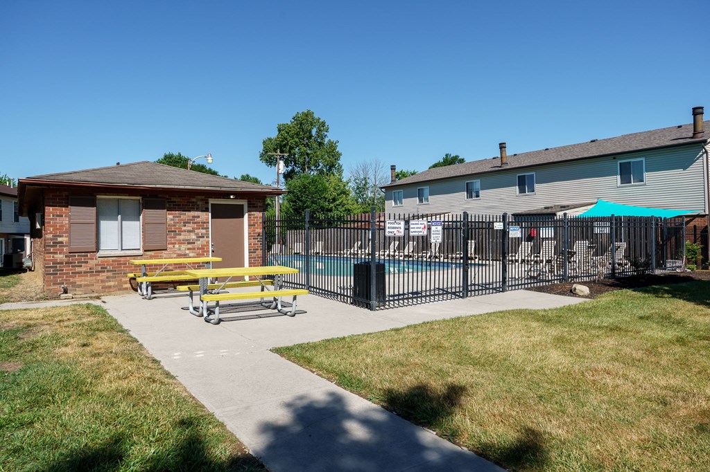 A small building with a yellow bench in front of it.