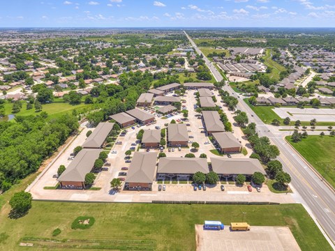 A large, modern building complex with a parking lot in front.