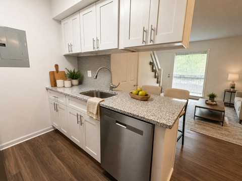 A kitchen with white cabinets and a granite countertop.