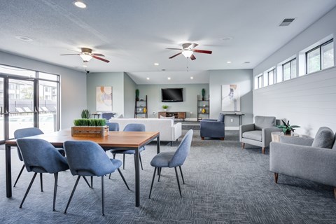 A modern living room with a dining table and grey chairs.