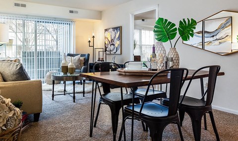 a living room and dining room with a table and chairs