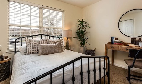 a bedroom with a bed and a potted plant