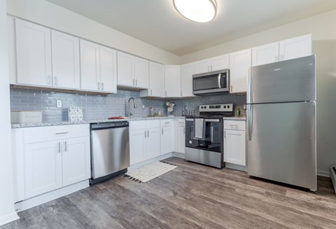 A kitchen with white cabinets and stainless steel appliances.