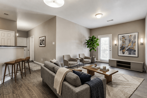 A living room with a grey couch and a wooden table.