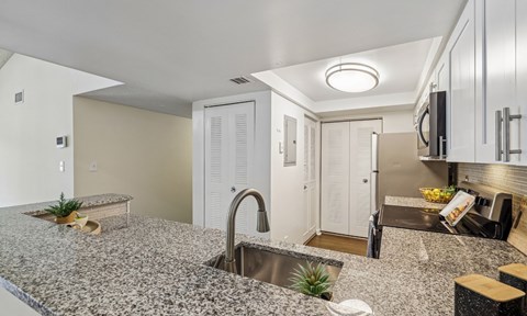 A kitchen with granite countertops and a sink.