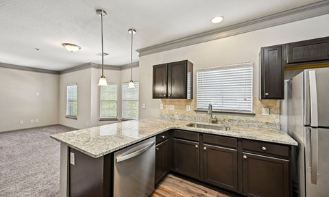 A kitchen with a granite countertop and stainless steel appliances.