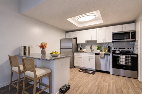 A kitchen with a counter and a chair.