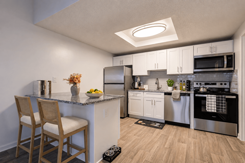 A kitchen with a white counter and stainless steel appliances.
