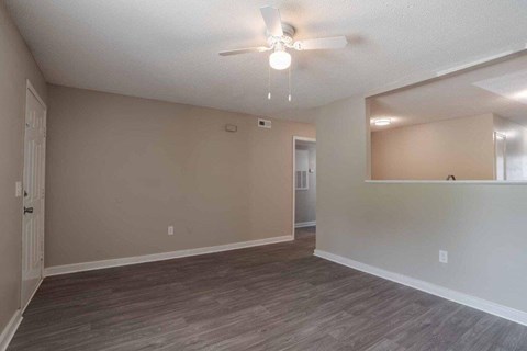 A room with a ceiling fan and a doorway leading to another room.