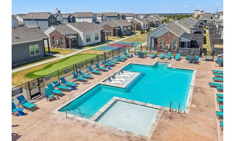 A large swimming pool surrounded by blue lounge chairs.