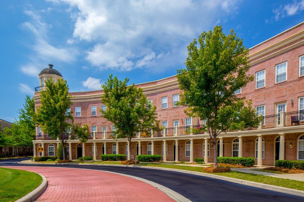 an exterior view of a brick building with trees
