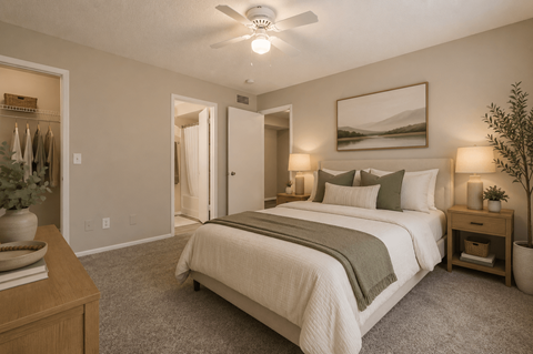 A bedroom with a large bed and a ceiling fan.