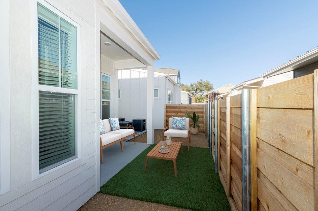 a patio with a table and chairs in a backyard