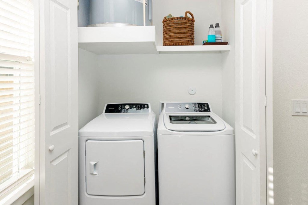 a white washer and dryer in a white laundry room