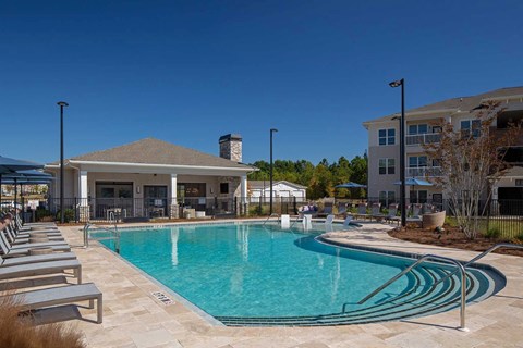 A swimming pool with a slide and sun loungers.