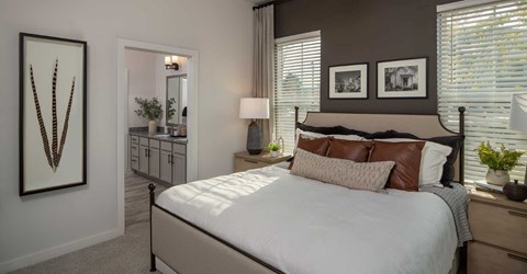 A bedroom with a large bed and a cactus on the wall.