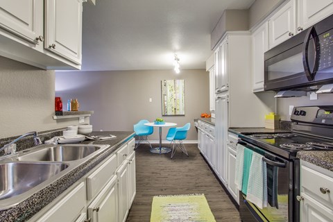 A kitchen with white cabinets and a black stove top oven.