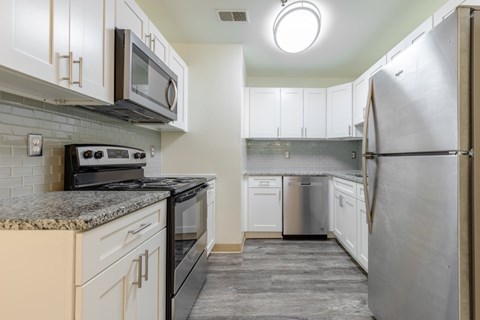 A kitchen with a black stove top oven and a black microwave.
