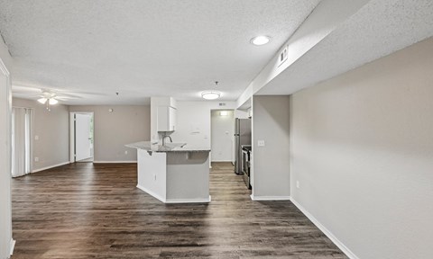 A kitchen area with a white island and wooden floors.