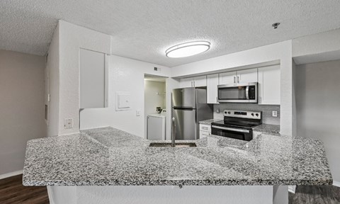 A kitchen with granite countertops and stainless steel appliances.