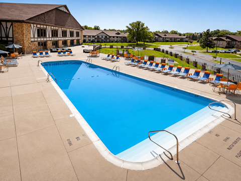 A large blue swimming pool surrounded by lounge chairs.