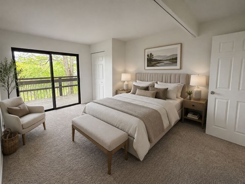 A bedroom with a large bed and a chair.