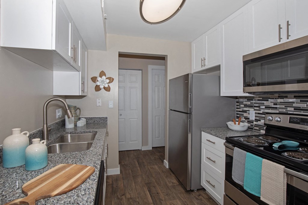 White Kitchen with Stainless-Steel Appliances and Granite Countertops
