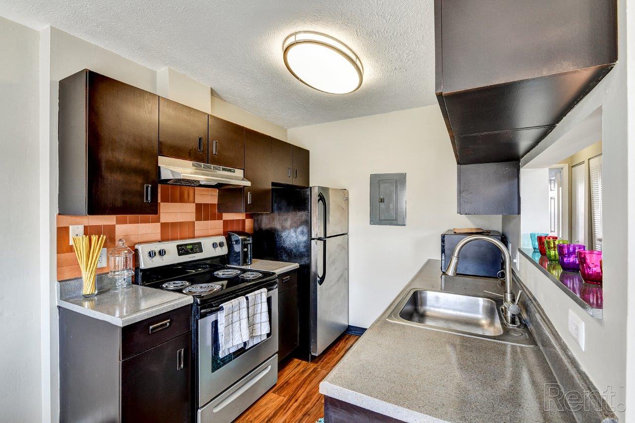 A modern kitchen with a stove top oven and a refrigerator.