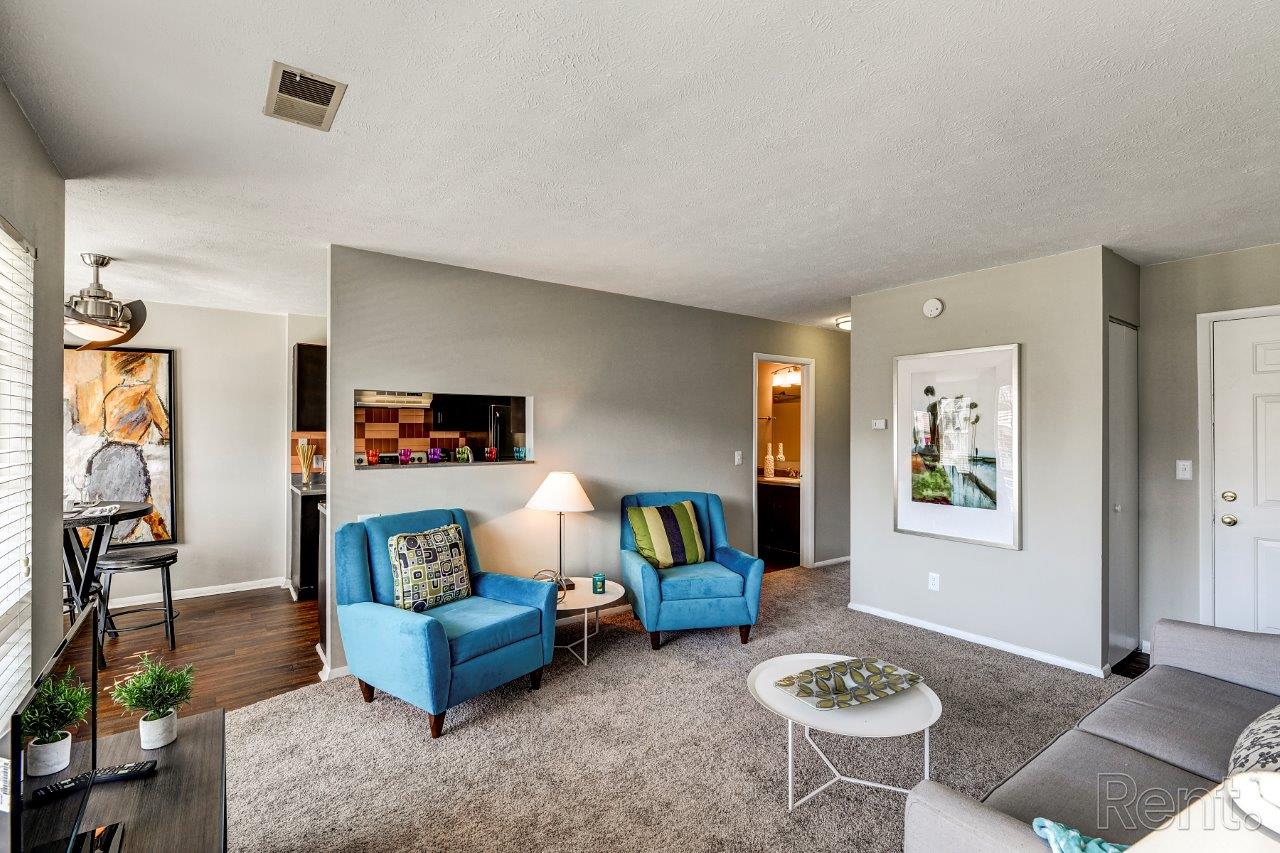 A living room with a grey couch and a blue chair.