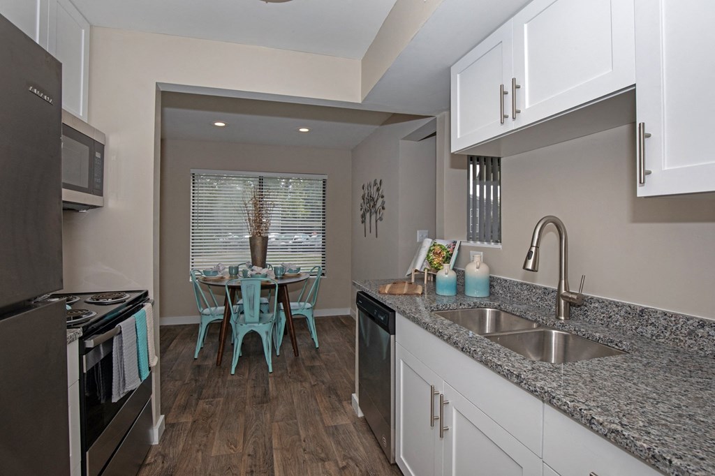 White Kitchen with Stainless-Steel Appliances and Granite Countertops