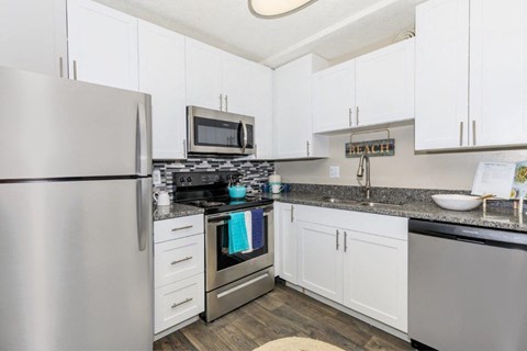 a kitchen with stainless steel appliances and white cabinets