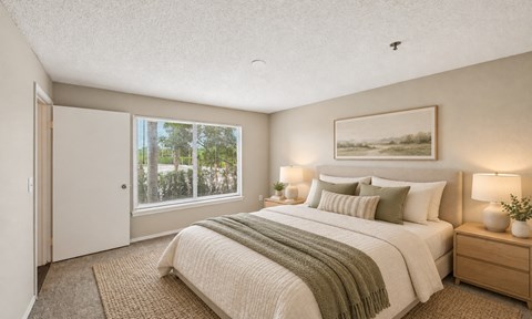 A bedroom with a large bed and a painting on the wall.