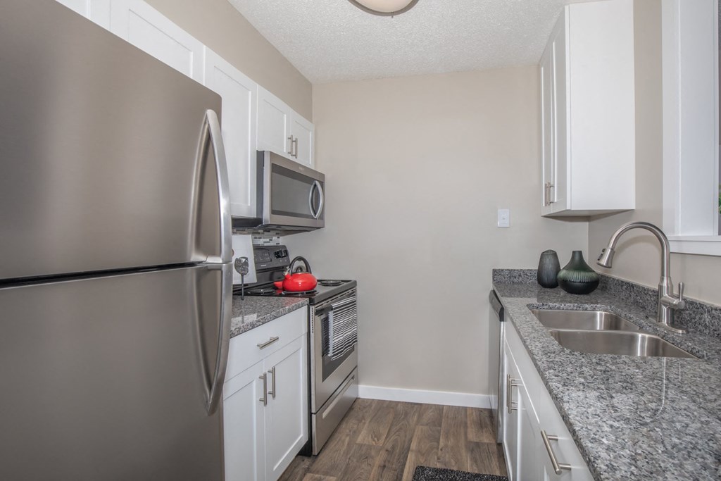White Kitchen with Stainless-Steel Appliances and Granite Countertops
