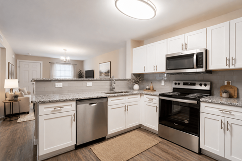 A kitchen with white cabinets and stainless steel appliances.