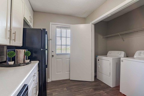 A black refrigerator sits next to a white door in a kitchen.