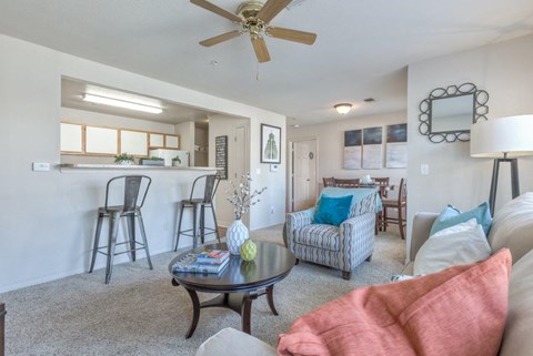 A living room with a couch, chairs, and a coffee table.