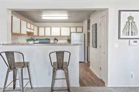 Two chairs are placed in front of a kitchen island.