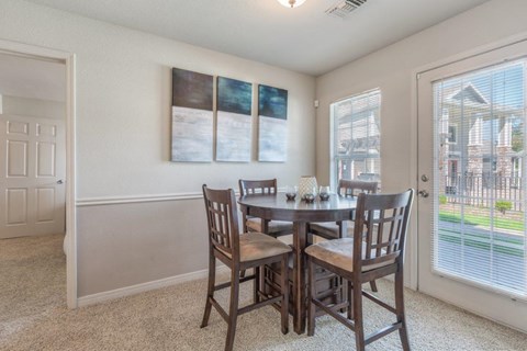 A dining room with a table and chairs.