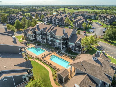 A large residential complex with a swimming pool in the foreground.