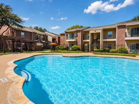 A swimming pool in front of apartment buildings.