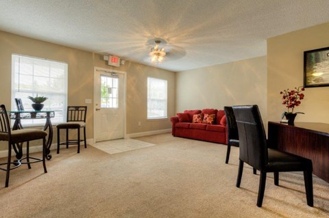 A living room with a red couch and a wooden table.