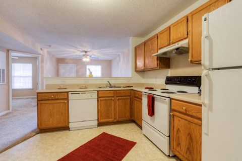 A kitchen with wooden cabinets and white appliances.