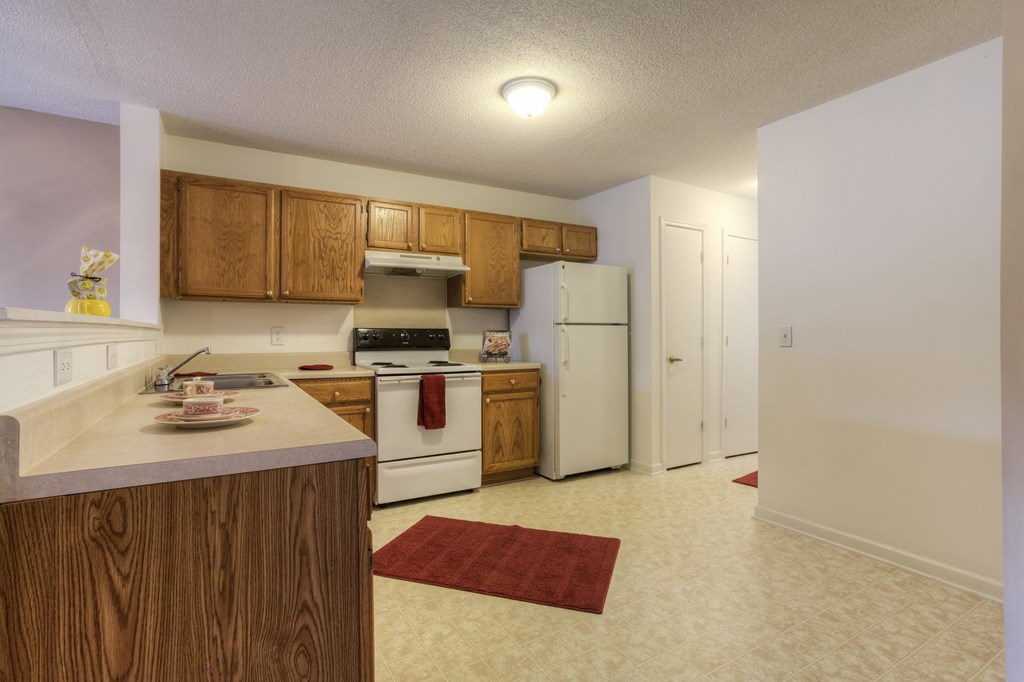 a kitchen with white appliances and wooden cabinets