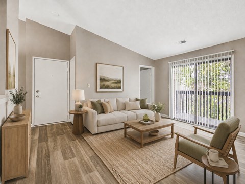 A living room with a white couch, a wooden coffee table, and a painting on the wall.