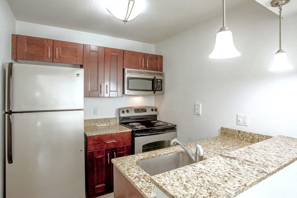 A kitchen with granite countertops and stainless steel appliances.