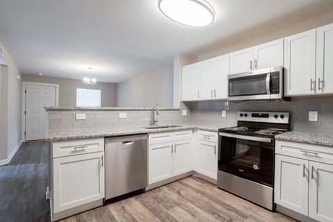 A kitchen with white cabinets and stainless steel appliances.