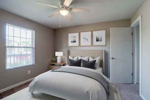 A bedroom with a large bed and a ceiling fan.