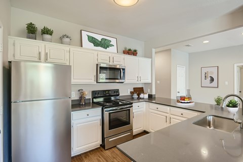 A modern kitchen with a stainless steel refrigerator and a microwave above the stove.