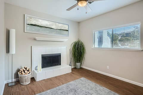 A living room with a fireplace and a painting above it.