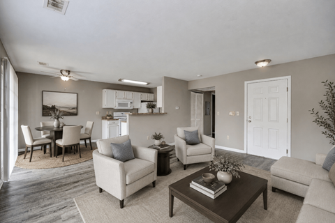 A living room with a white door, a brown coffee table, and a grey couch.
